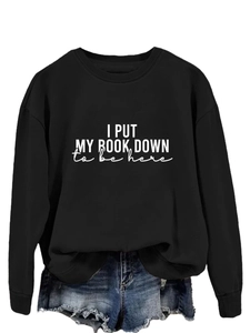 Detail of black crewneck sweatshirt with I PUT MY BOOK DOWN white letter printing