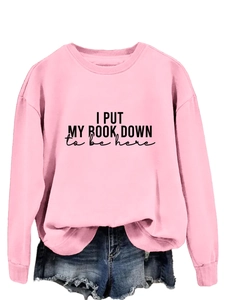 Detail of pink long sleeve sweatshirt with 'I PUT MY BOOK DOWN' slogan print