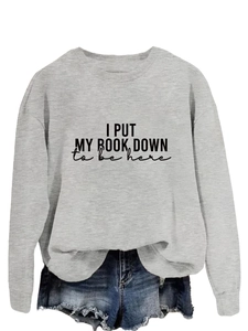 Close-up of the slogan print and knit texture on this light gray long-sleeve sweatshirt
