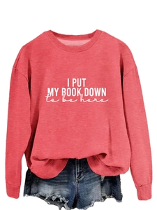 Detail of red crewneck sweatshirt with 'I PUT MY BOOK DOWN' white printed text