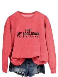 Detail of pink crewneck sweatshirt featuring I Put My Book Down letter print and cotton fabric