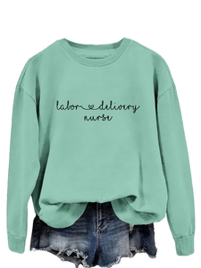 Détail de l'imprimé labor & delivery nurse sur un sweatshirt vert menthe à manches longues