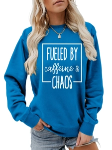 Detail of blue crewneck sweatshirt featuring white FUELED BY caffeine and CHAOS print