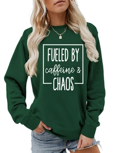 Detail of dark green crewneck sweatshirt featuring white FUELED BY CAFFEINE print