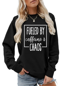 Detail of Fueled by Caffeine and Chaos typography on black crewneck sweatshirt fabric