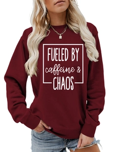 Detail of burgundy crewneck sweatshirt featuring white FUELED BY caffeine and CHAOS print