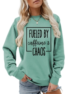 Detail of teal sweatshirt showing ribbed crewneck and Fueled by Caffeine and Chaos print