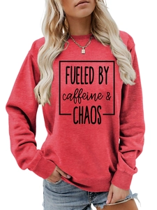 Detail of red crewneck sweatshirt with black FUELED BY caffeine & CHAOS print on chest