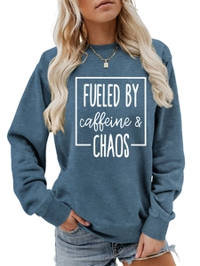 Close-up of blue crewneck sweatshirt featuring white FUELED BY caffeine & CHAOS text