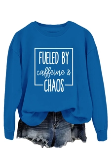 Detail of blue crewneck sweatshirt with Fueled by Caffeine and Chaos printed text