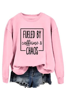 Detail of pink crewneck sweatshirt with 'FUELED BY caffeine chaos' black print text