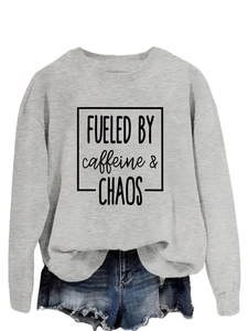 Detail of grey crewneck sweatshirt featuring black 'FUELED BY caffeine & CHAOS' print