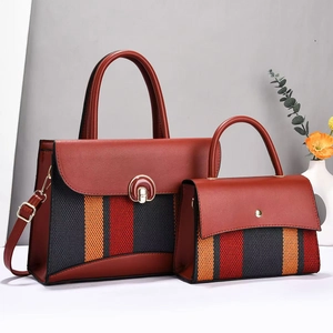 Detail eines zweiteiligen Handtaschen-Sets mit rotem Kunstleder und gestreiftem Webstoff