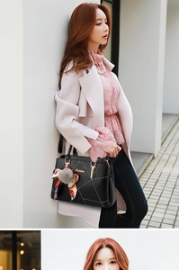 Dettaglio borsa in pelle nera con cuciture bianche, finiture dorate e foulard di seta