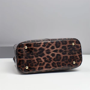Detail view of leopard print handbag bottom with golden protective metal feet