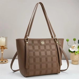 Detail view of coffee brown checkered tote bag with gold logo and shoulder strap