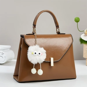 Braune strukturierte Kunstleder-Handtasche mit goldenem Schloss und flauschigem Anhänger