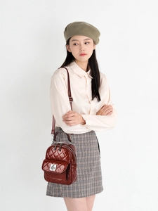 Burgundy quilted checkered backpack with metallic bird logo and adjustable straps