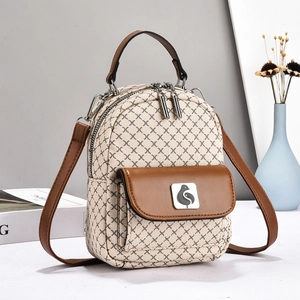 Detail of checkered beige backpack with brown leather pocket and gold bird logo ornament