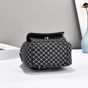 Detail view of mini black checkered backpack with silver metal zippers and hardware
