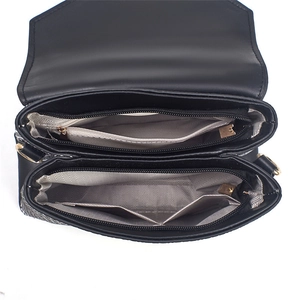 Detail of black leather handbag featuring dual zipper compartments and herringbone lining