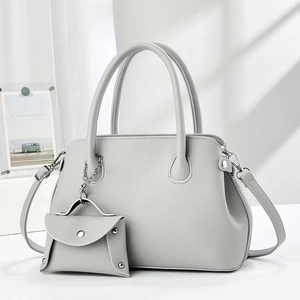 Detail of grey pebbled leather shell bag with matching mini coin purse and silver hardware