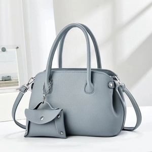 Detail of blue pebbled leather handbag set with silver chain and matching wallet charm