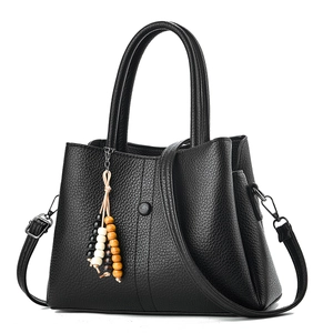 Sac à main classique en cuir grainé noir avec pompon perlé et bandoulière