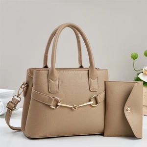 Détail du sac à main beige en cuir texturé avec mors doré et son portefeuille assorti