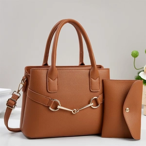 Détail du sac à main en cuir marron avec mors doré et portefeuille assorti