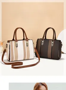 Detail of color-block striped tote bags with retro woven texture and gold metal hardware