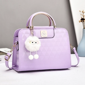 Close-up of lilac glossy bag with geometric embossing and white plush monster charm