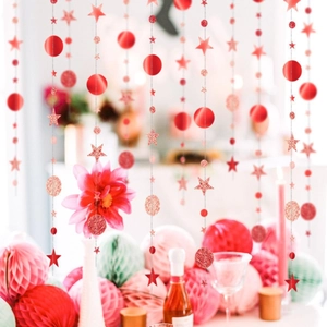 Close-up of sparkling red stars and glitter circle garlands for festive party decorations