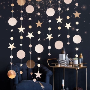 Close-up of glittery rose gold star and circle garland hanging in festive indoor setting