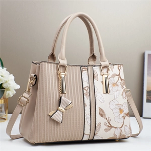 Detail of elegant handbag featuring geometric texture and vintage floral print patterns