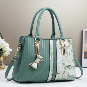 Elegant mint green tote bag with floral print and gold hardware on a minimalist background