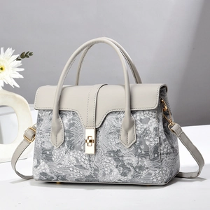 Elegant grey handbag with cloud embroidery and gold lock on minimalist marble background