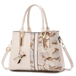 Sac à main blanc cassé élégant avec broderie florale et détails dorés brillants