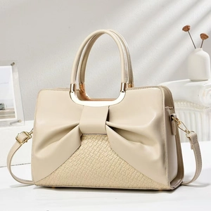 Chic beige handbag with elegant bow design and crocodile texture for luxury styling