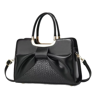 Elegant black handbag with bow pleats and woven texture, crossbody and top-handle style
