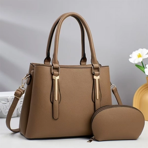 Detail view of khaki pebbled leather tote bag set with golden hardware and matching pouch