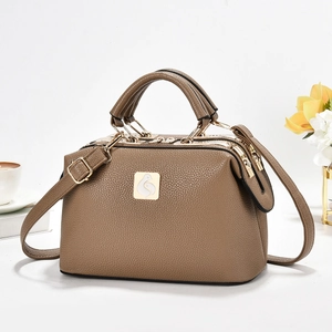 Detail of brown litchi pattern leather bag with triple zippers and gold logo plate