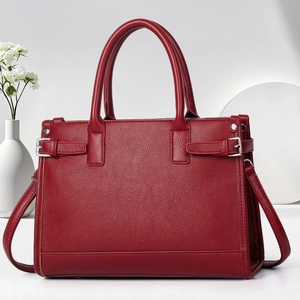 Detail of dark red tote bag featuring premium lychee texture leather and silver metal buckles