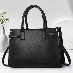 Detailed view of black lychee grain leather tote bag with metal buckles and dual handles