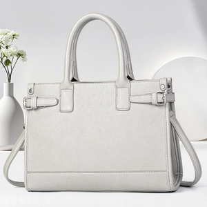 Macro shot of light gray leather tote bag with lychee grain texture and metal buckle detail