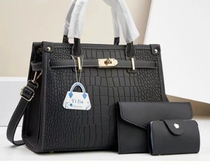Detailed close-up of a black crocodile-pattern handbag set with classic buckle hardware