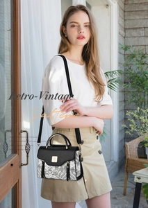 Close-up of retro wave pattern shoulder bag with metal handle and golden logo detail