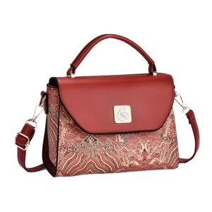 Red traditional wave pattern crossbody handbag with golden metal lock on white background