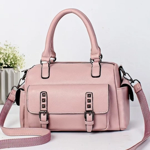 Detailed macro view of pink pebbled leather Boston bag with metal rivets and side pockets