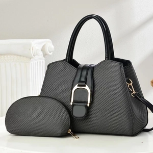 Black fabric tote bag with gold horsebit detail and matching small pouch on a pedestal
